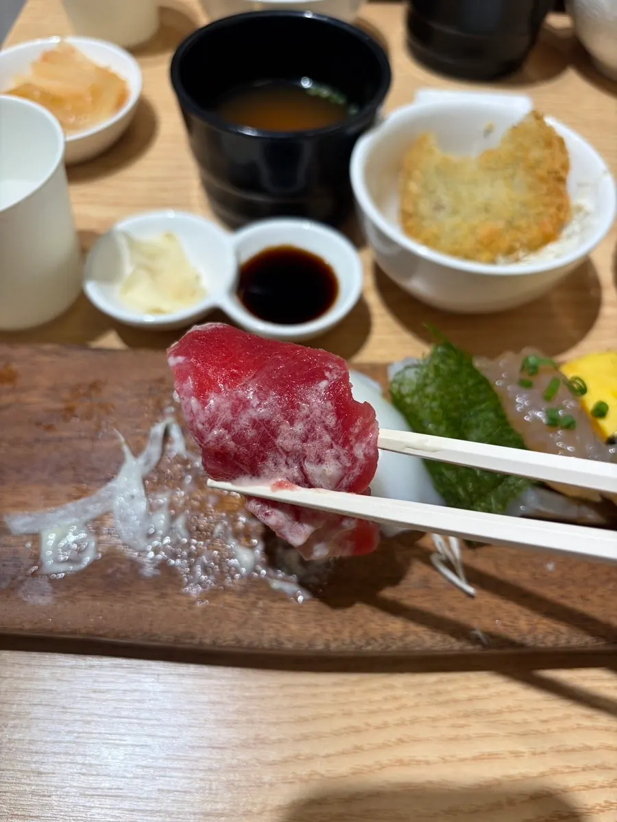 A piece of sushi picked up with chopsticks