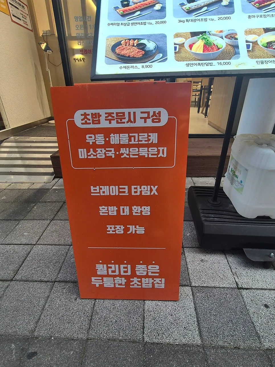 Signboard outside the store noting udon and seafood croquette included with orders