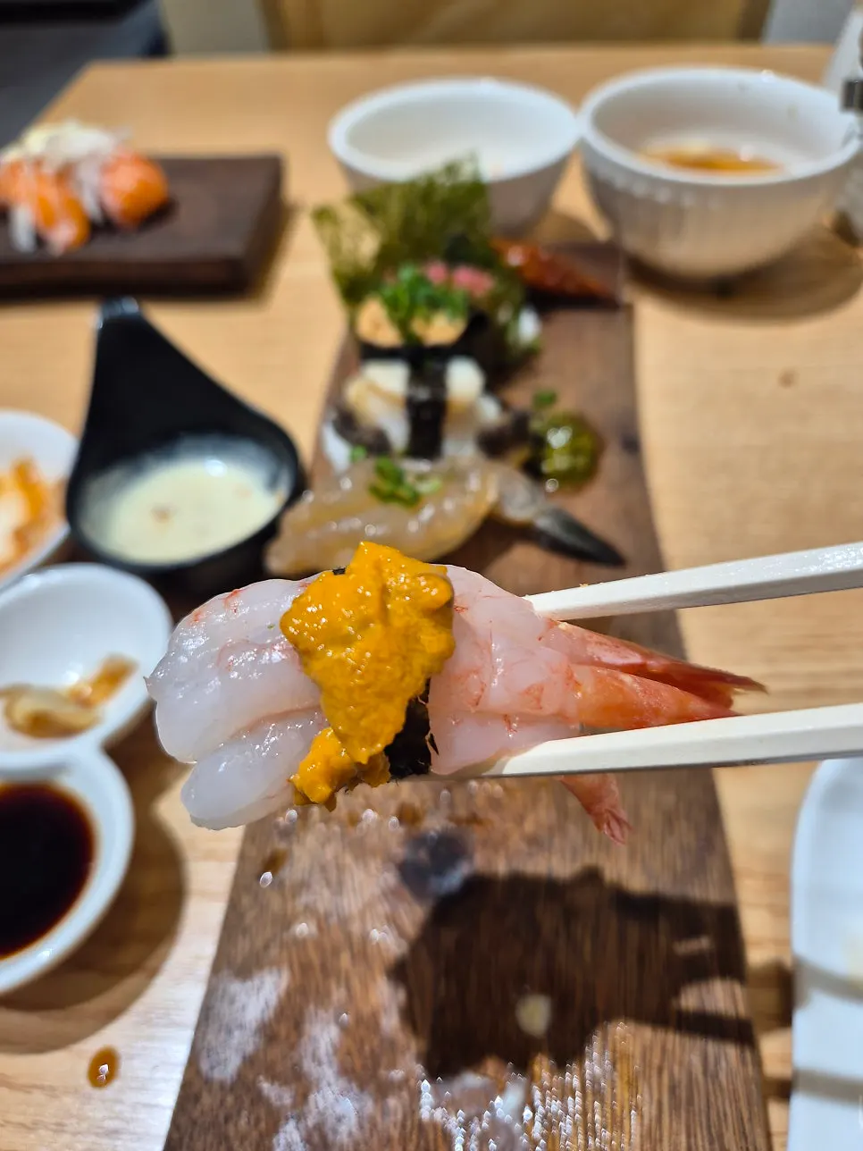 Sushi piece topped with sea urchin over shrimp