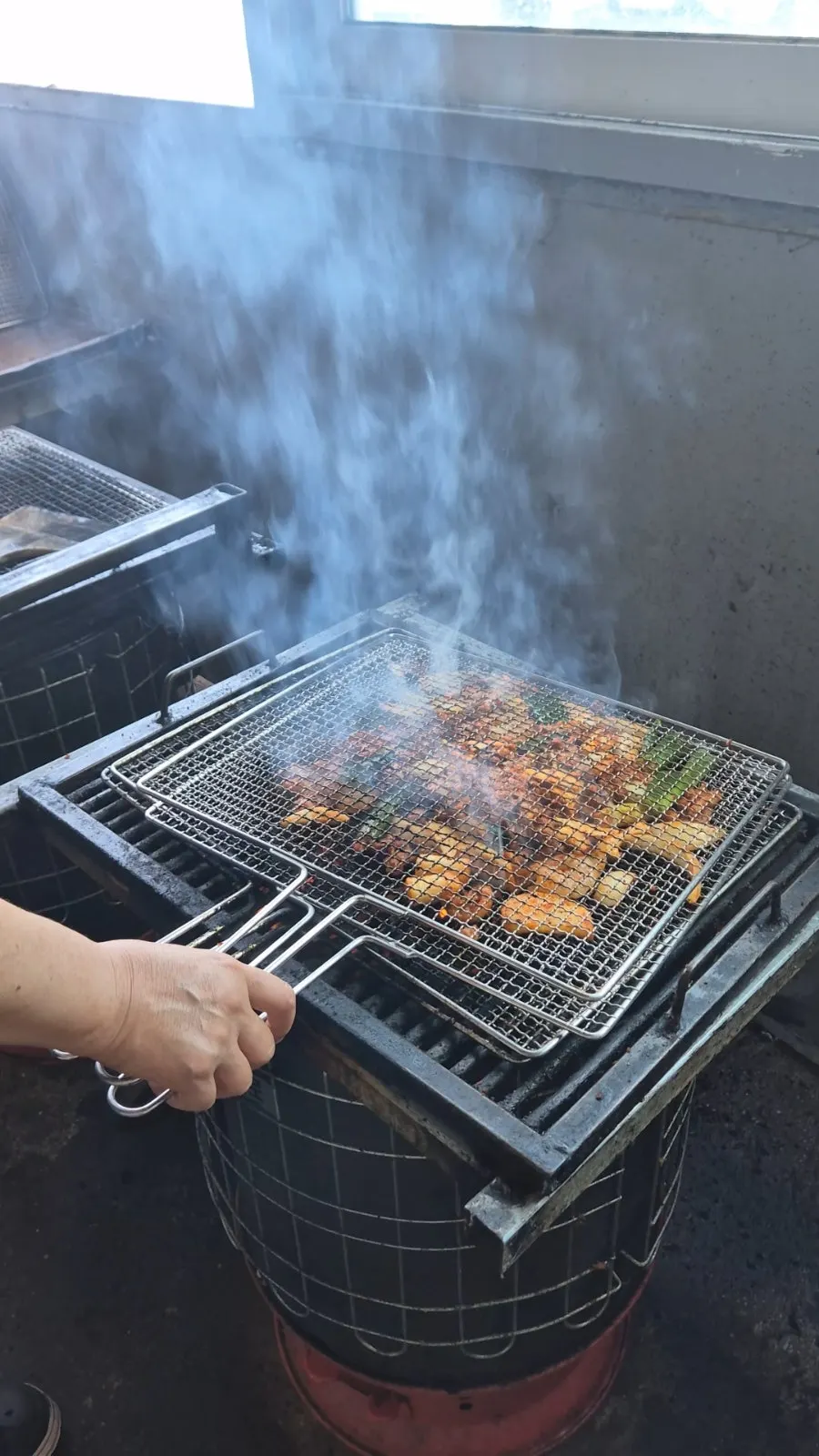 Flames rising as the grate is slammed onto the charcoal drum