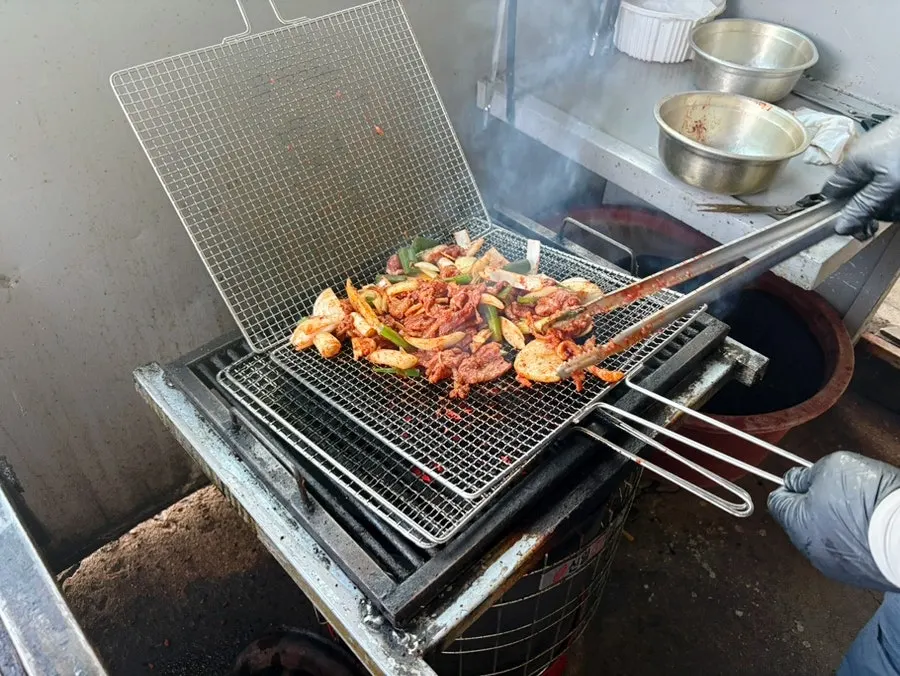 Duck jumulleok being par-grilled over charcoal