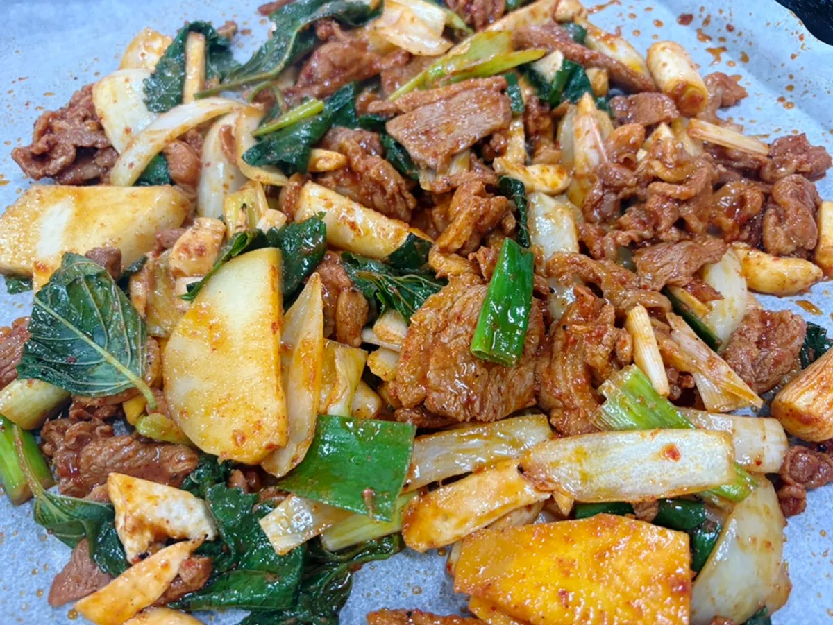 Table grill piled with duck jumulleok and perilla leaves