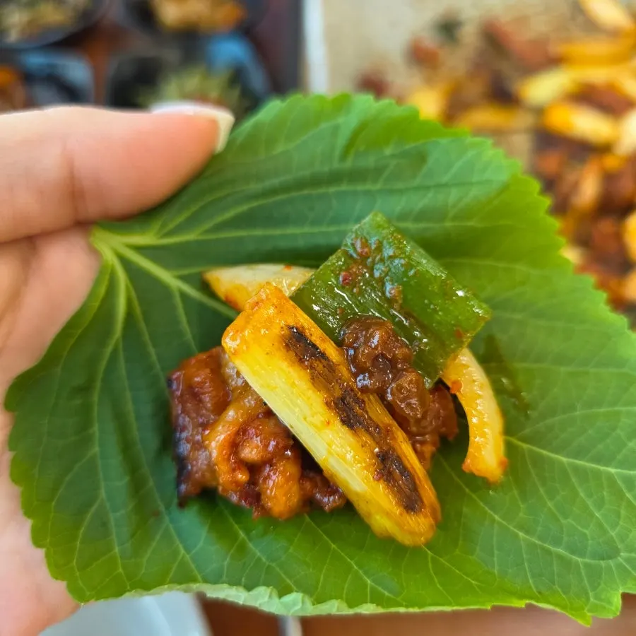 Duck meat and side dishes wrapped together in a lettuce wrap