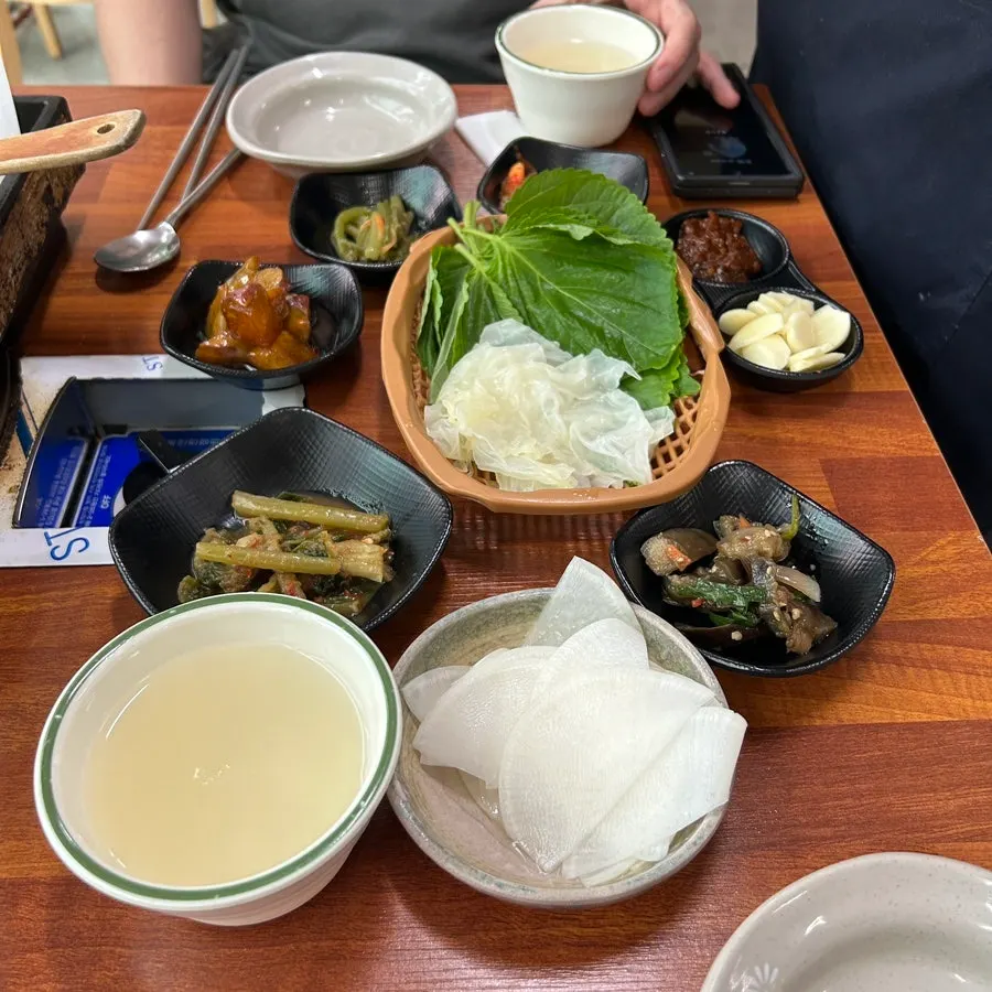 동치미와 가지무침, 고구마맛탕이 놓인 밑반찬 상차림