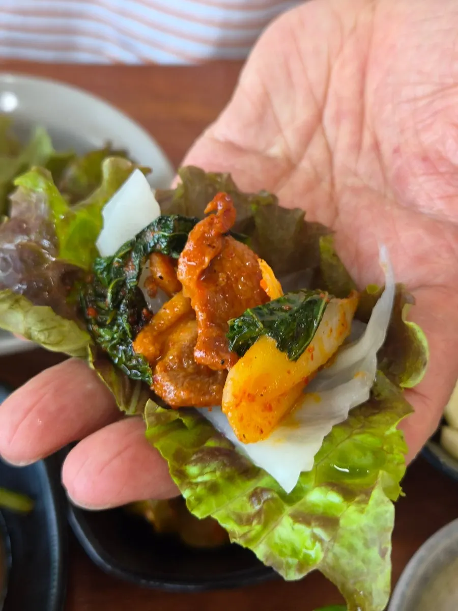 A piece of duck meat wrapped in lettuce