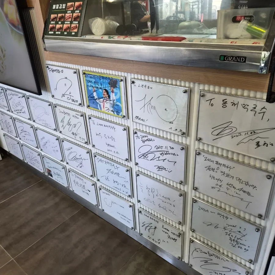 고씨네동해막국수 1층 벽면을 채운 싸인지