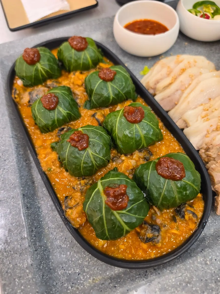 트레이에 담긴 보쌈과 비빔국수, 쌈밥 구성