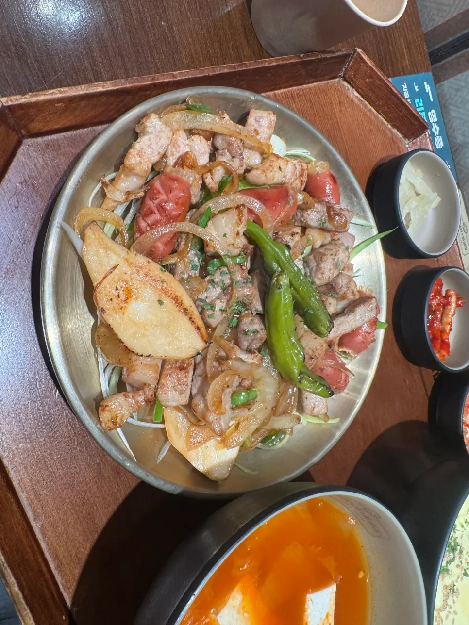 나무 쟁반에 차려진 고기 한상과 김치찌개, 계란찜