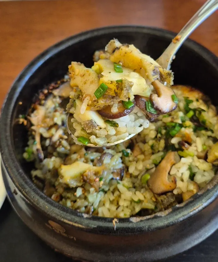 Close-up of the hotpot rice topped with abalone and mushrooms