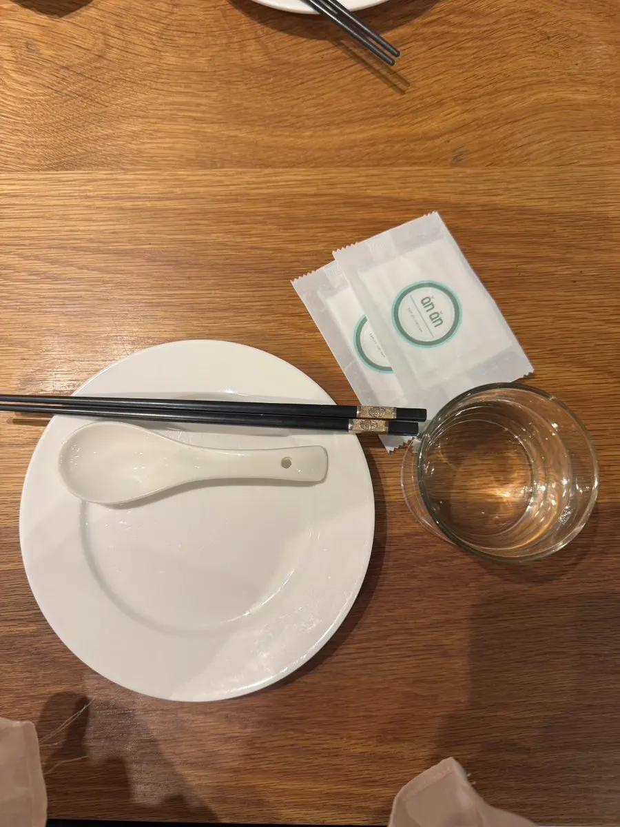 Table at Anan set with plates, tissues, and grapefruit water