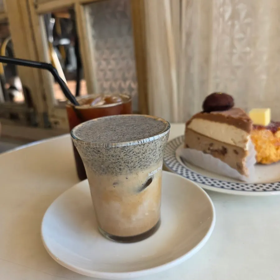 A cup of black sesame cream latte topped with cream