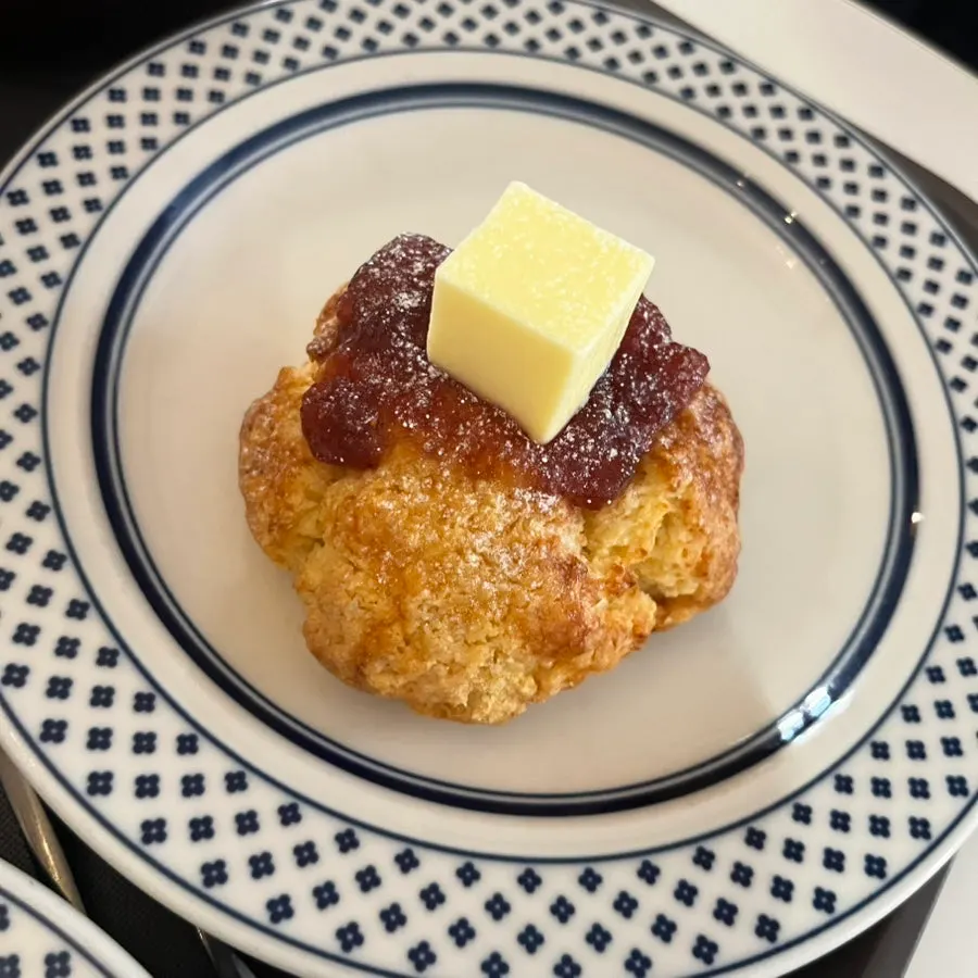 Strawberry butter scone topped with butter and strawberry jam