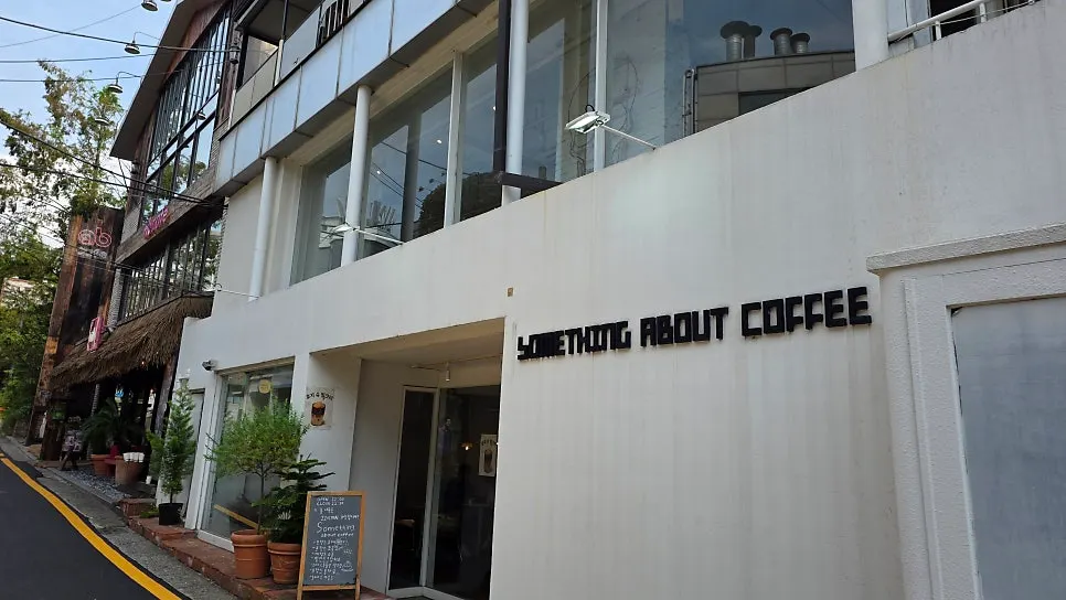 Café entrance with plants and a signboard