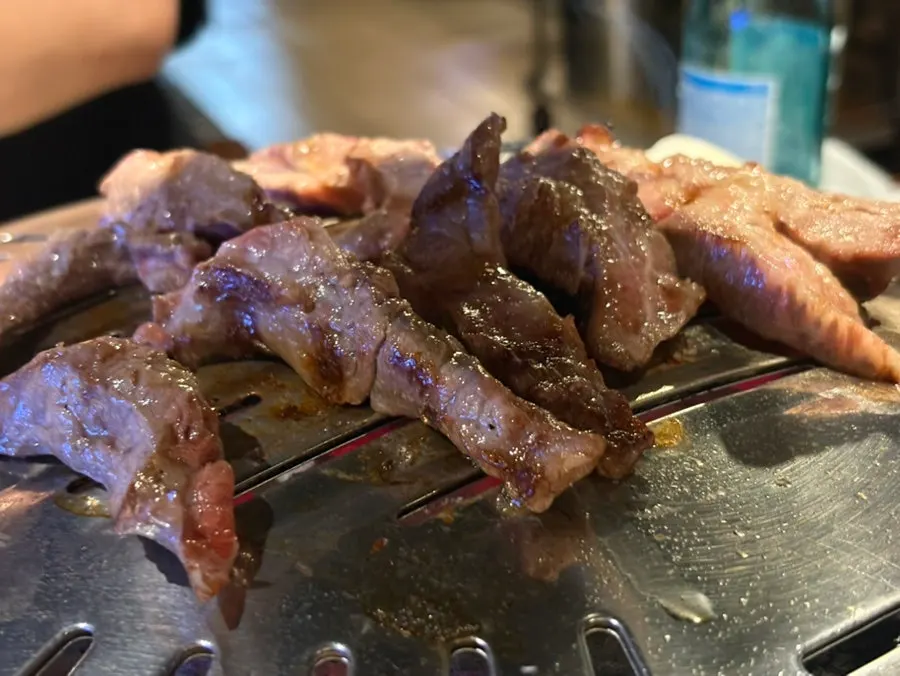 Table with grilled meat and banchan laid out together