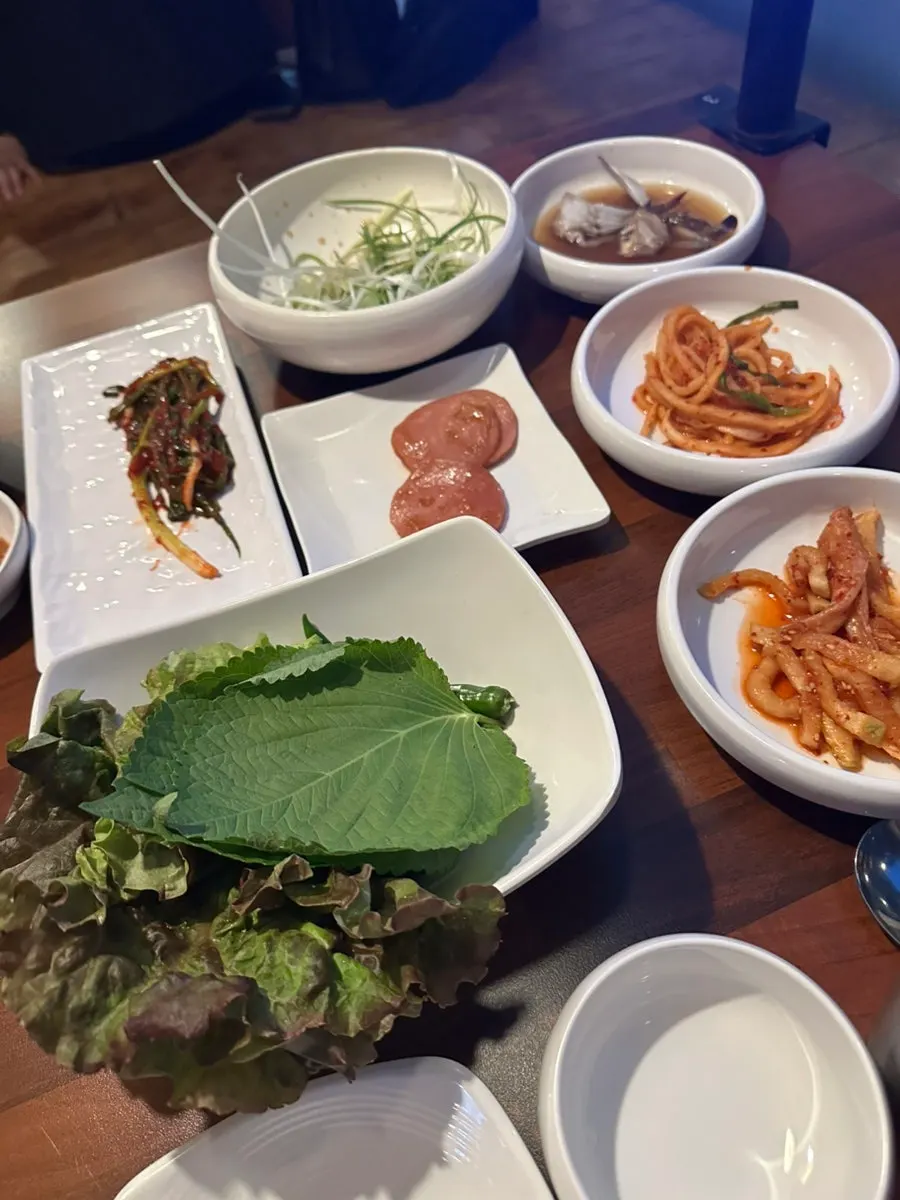 Basic banchan setup at Bongu Hwarro with lettuce, perilla leaves, and scallions