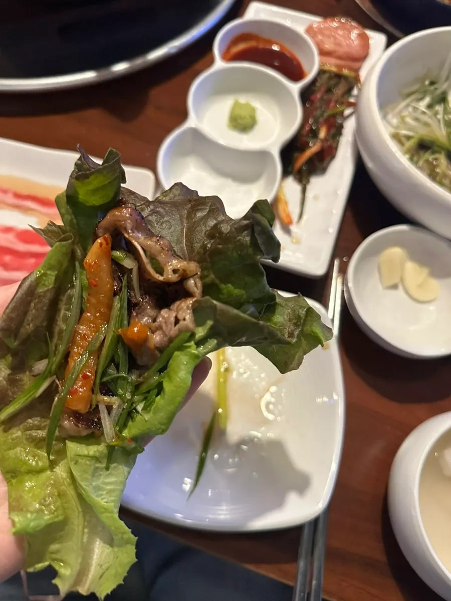 A perilla leaf wrap with woo-samgyeop and scallions