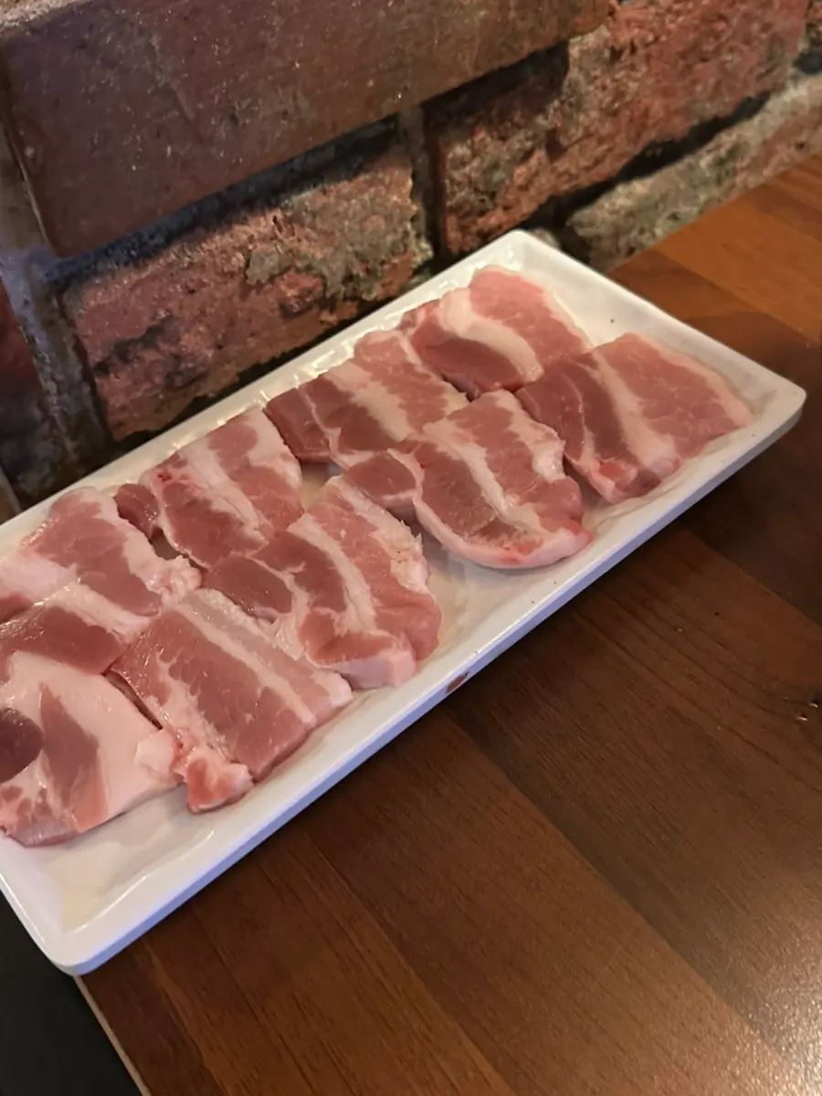 Fresh domestic pork belly on a newly changed grill plate