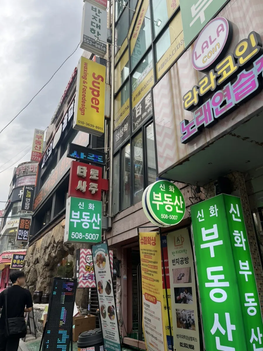 Exterior of the Gangnam Station building with the yellow Super Waxing sign