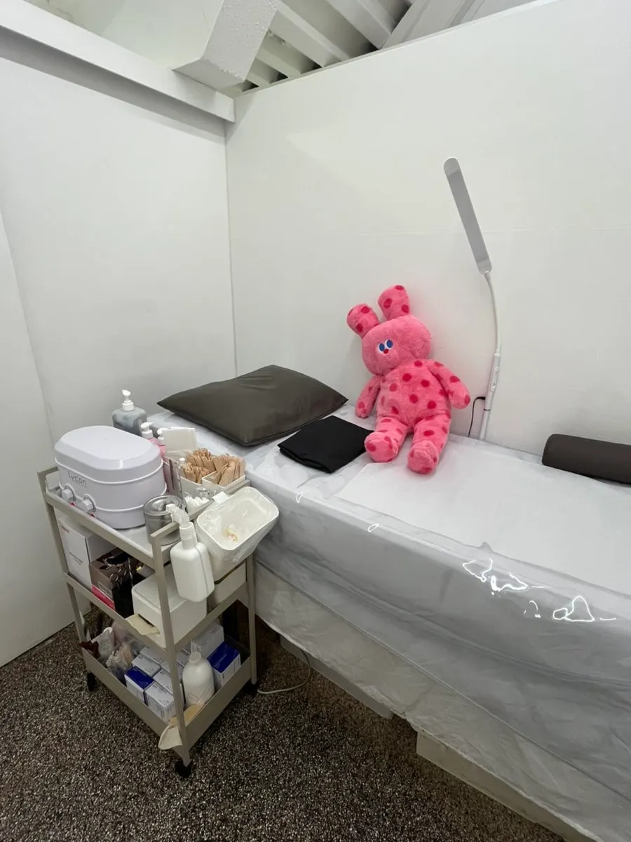 Private waxing room with a bed and hanger