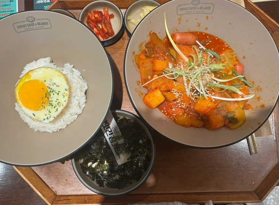 Sausage-packed jjageuli topped with fried egg and seaweed flakes