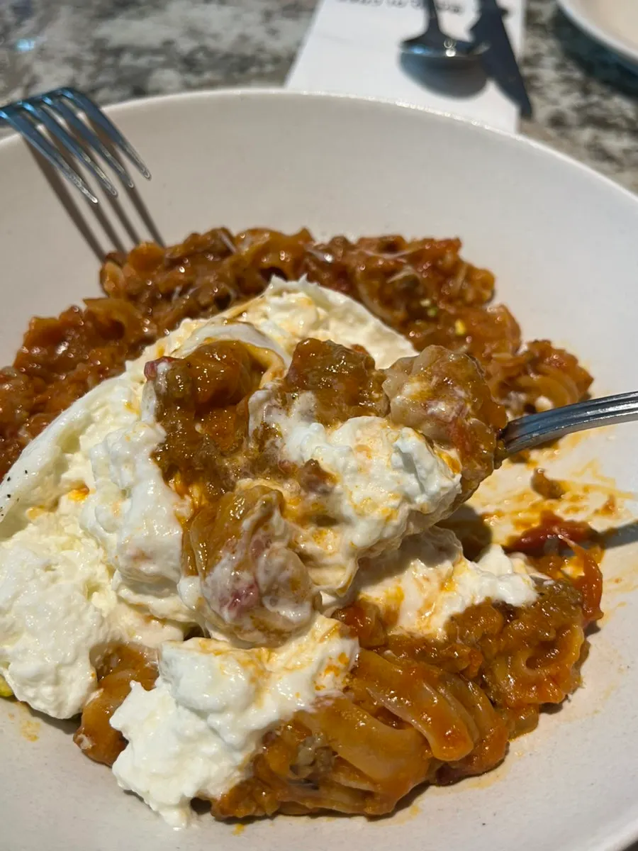 Bolognese pasta with a large burrata cheese