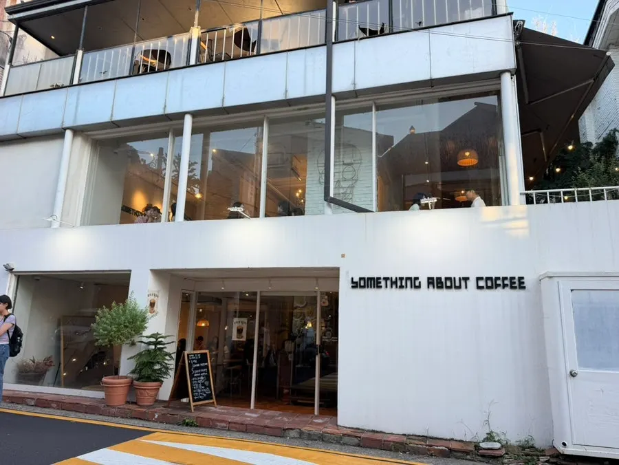 Exterior of the large white-toned Something About Coffee café