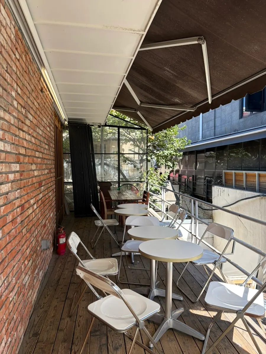 Sunlit terrace seating at Upper and Under