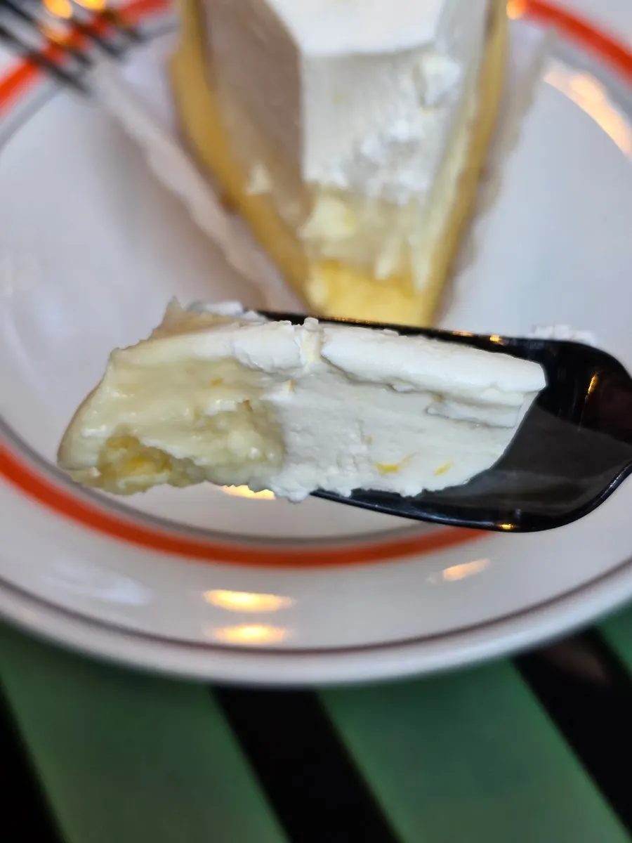 A slice of lemon yogurt gâteau fresh cream cake cut with a fork