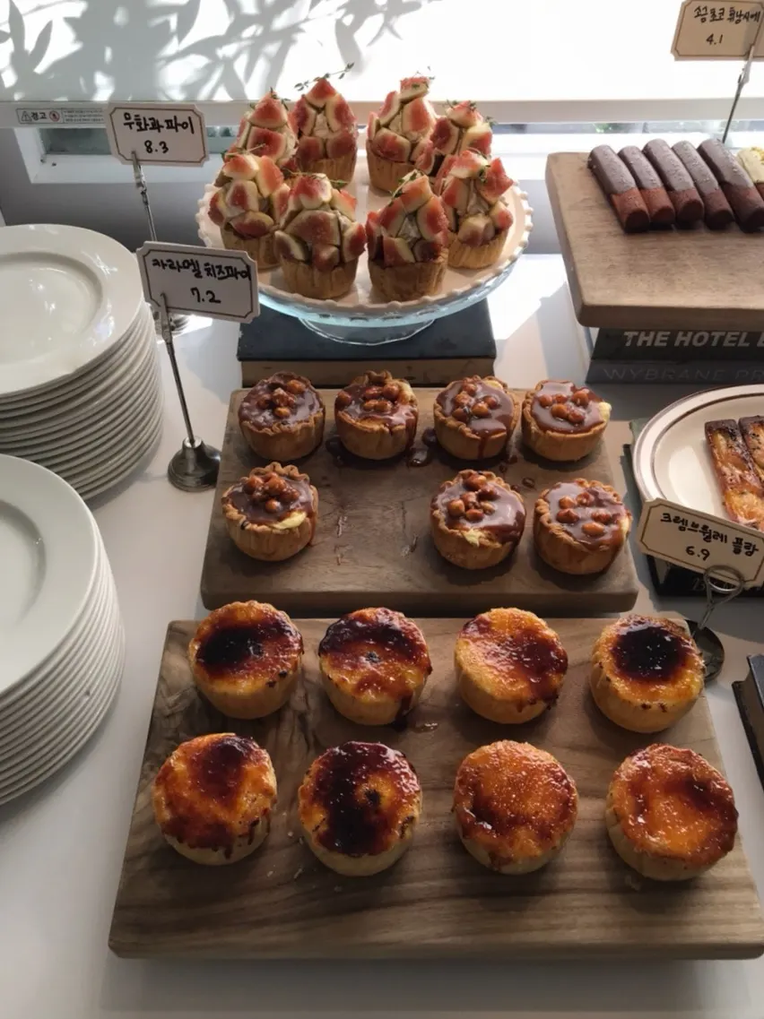 Display case with tiramisu, fig, raspberry, lemon, and grapefruit slice cakes
