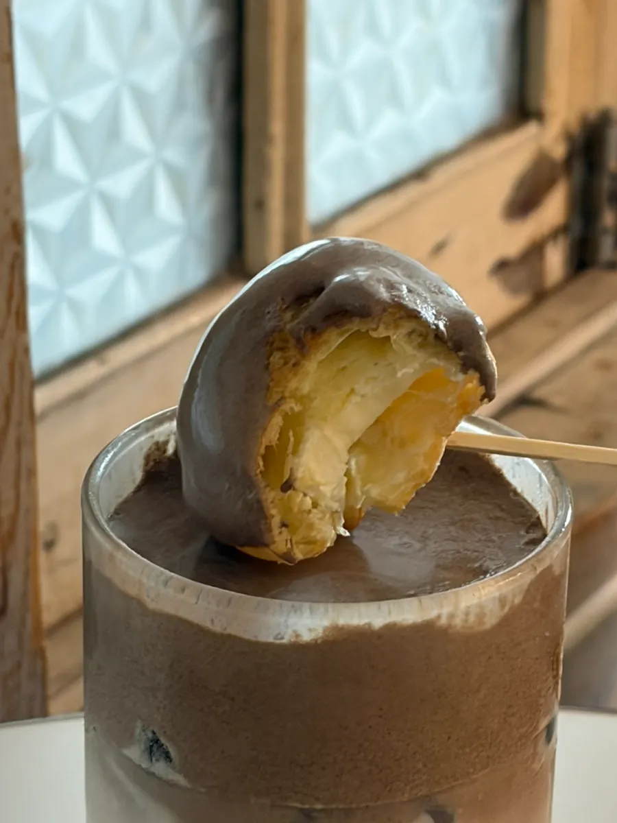 Cross-section of the mini choux on top of the hojicha milk tea