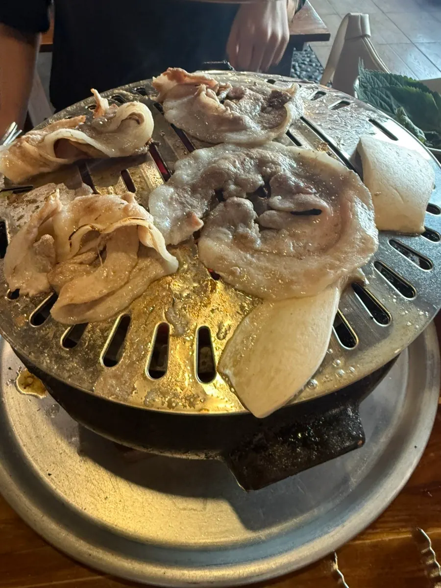 Pork belly and mushrooms grilling on the griddle