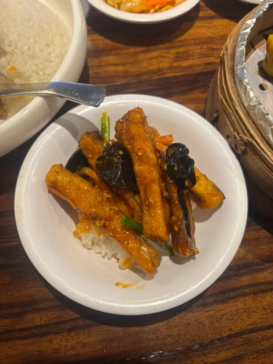 Close-up of sauced eggplant on top of the rice bowl