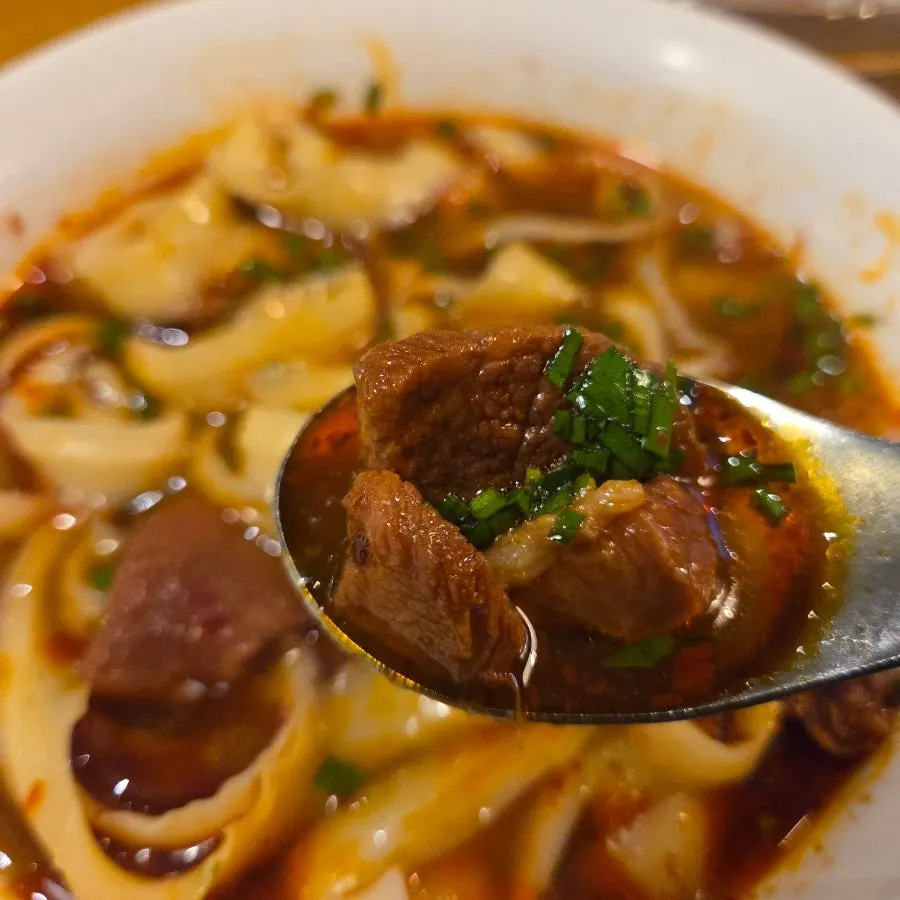 A bowl of beef dosakmyeon topped with large chunks of beef