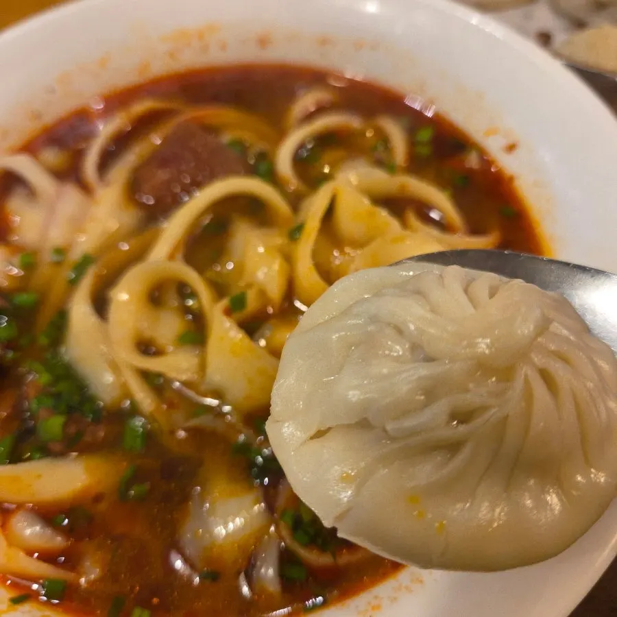 Xiaolongbao on a spoon with its broth