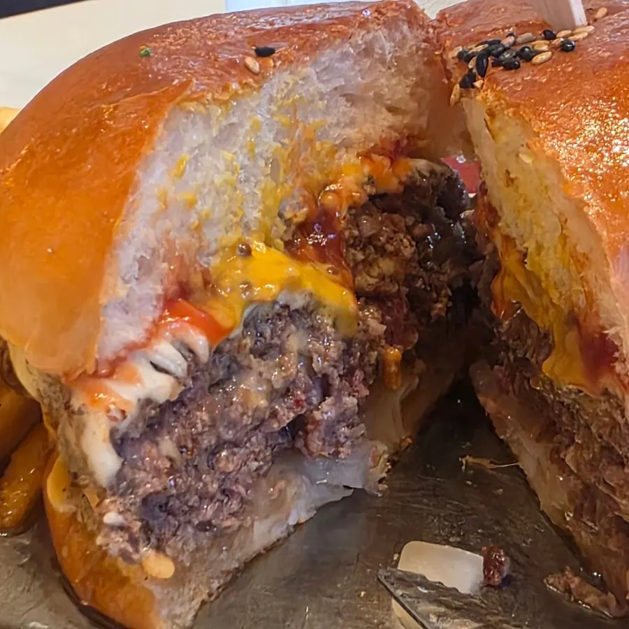 Cutting the double cheeseburger with a knife