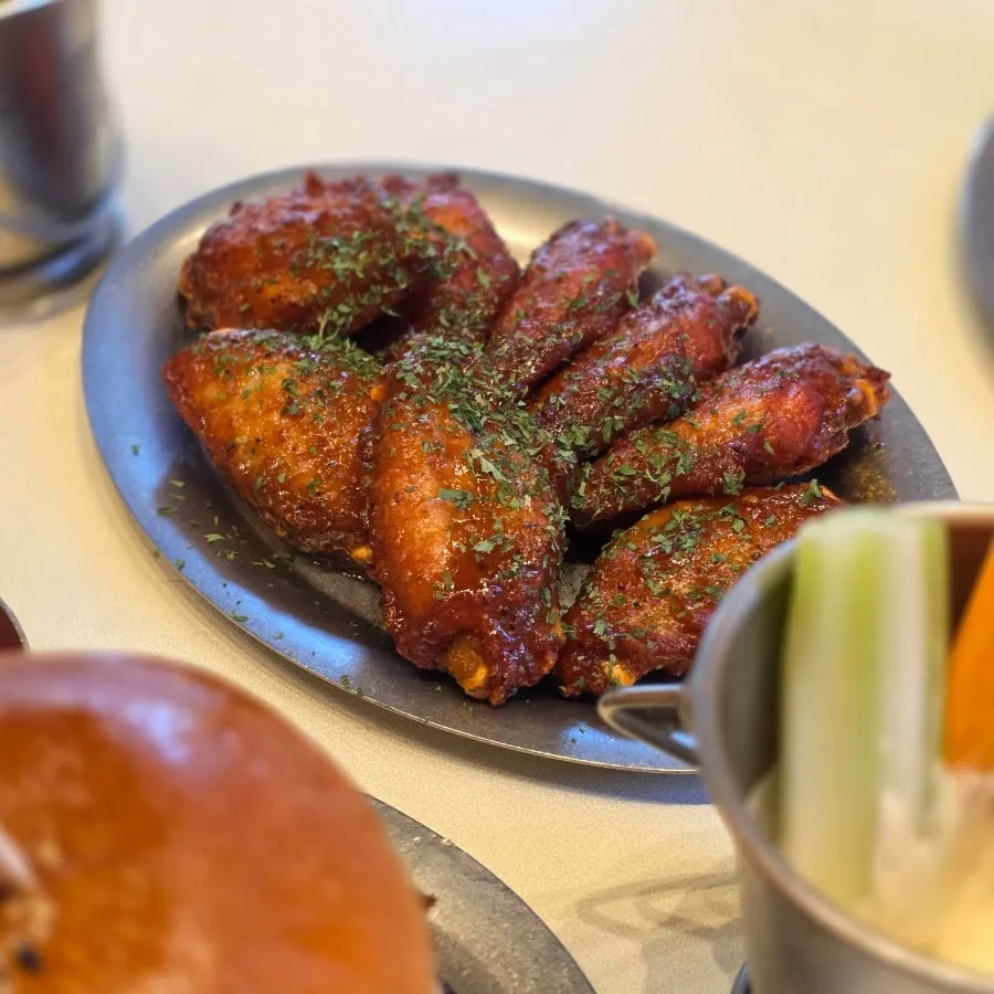 Plate of hot wings served with veggie sticks