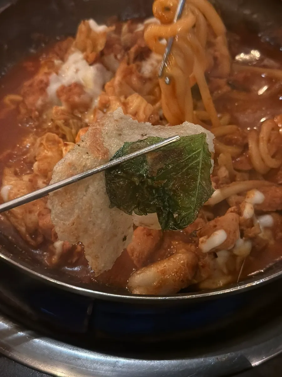 A bite of dakgalbi picked up together with cheese