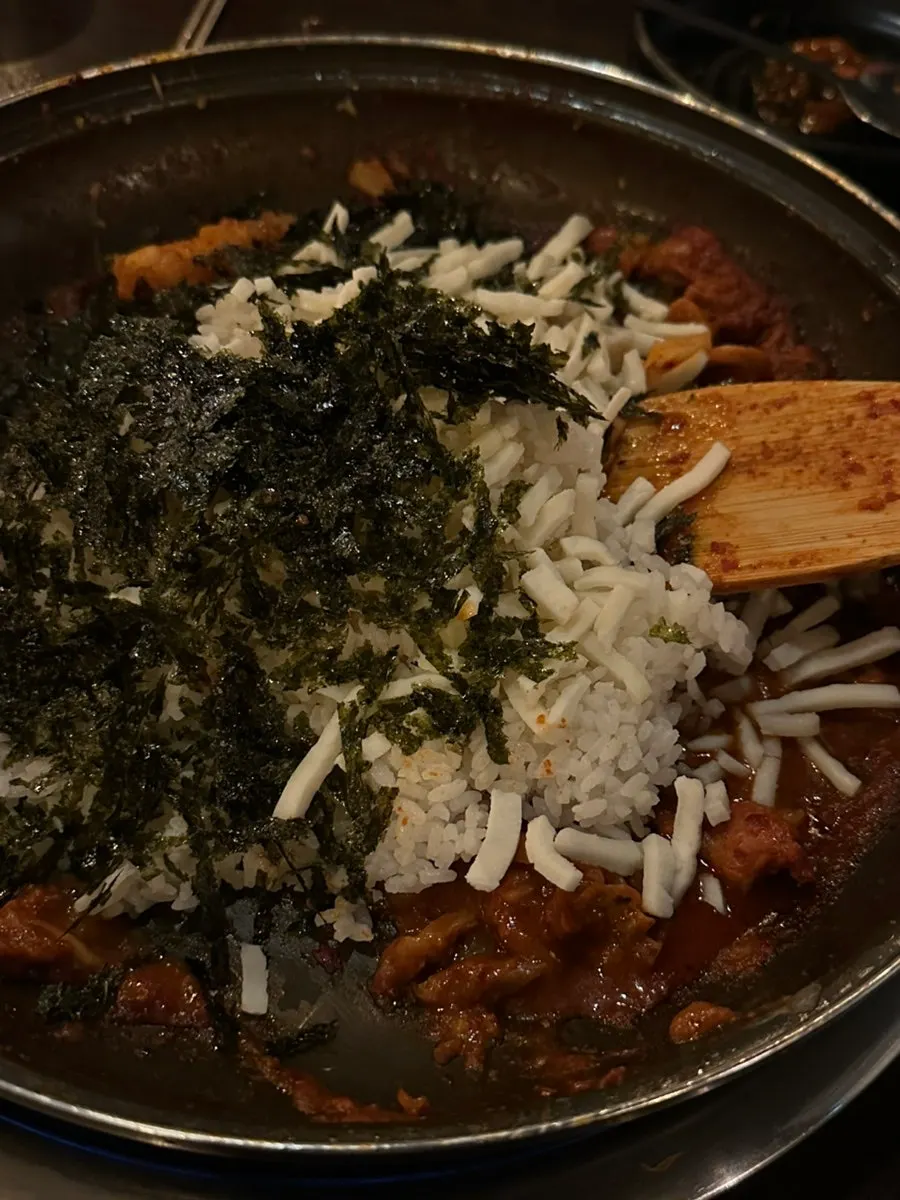 Cheese fried rice being cooked in the leftover sauce