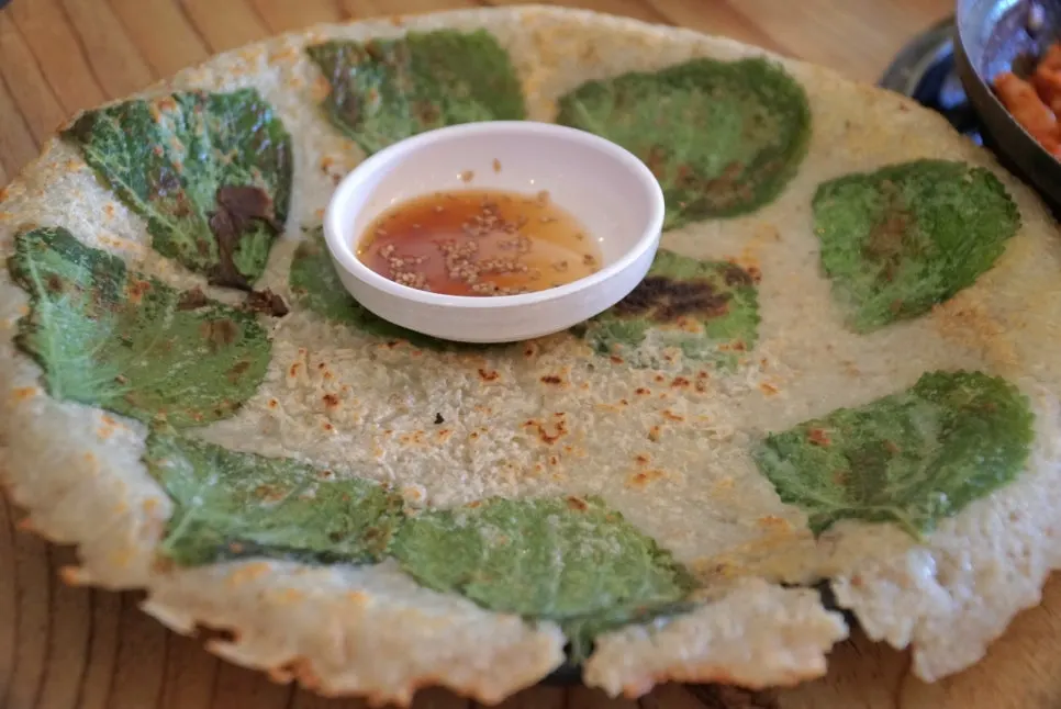A bite of dakgalbi placed on potato pancake