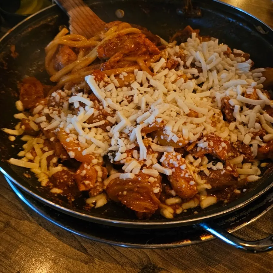 Seasoned dakgalbi sizzling on the hot plate