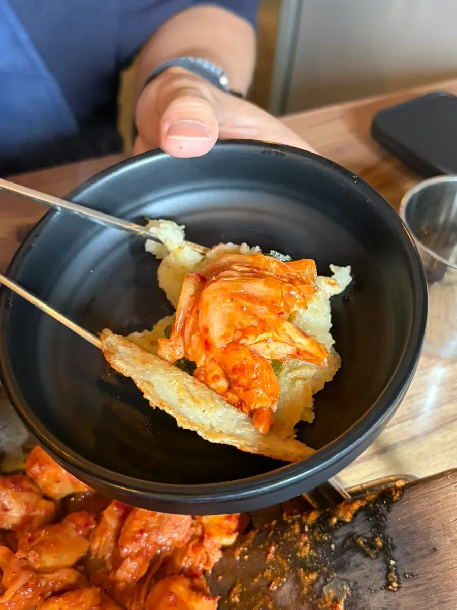 Wrapping dakgalbi in perilla-leaf potato pancake