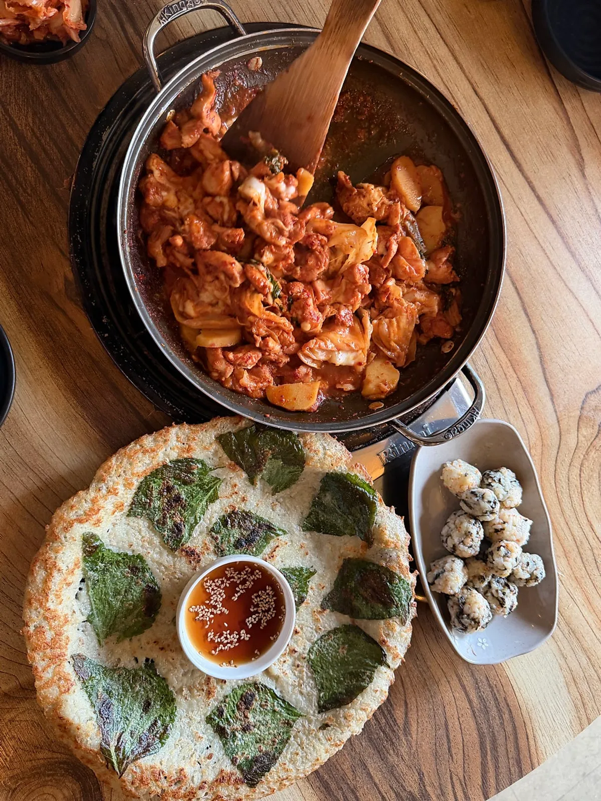 A bite of dakgalbi wrapped in potato pancake