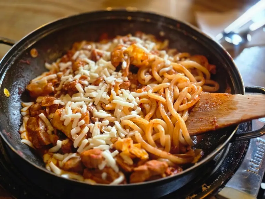 Cheese dakgalbi (gamssachidak) served on a hot plate