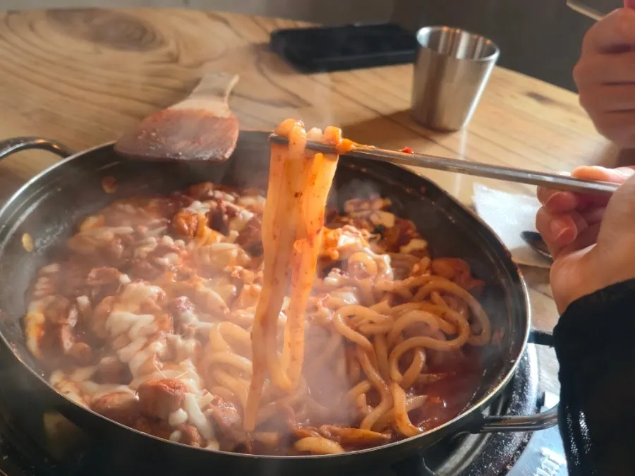 Hot plate of dakgalbi topped with melted cheese