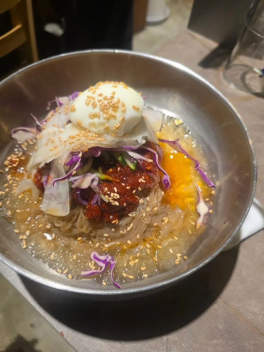 Pork skin dipped in rice cake powder alongside a glass of soju