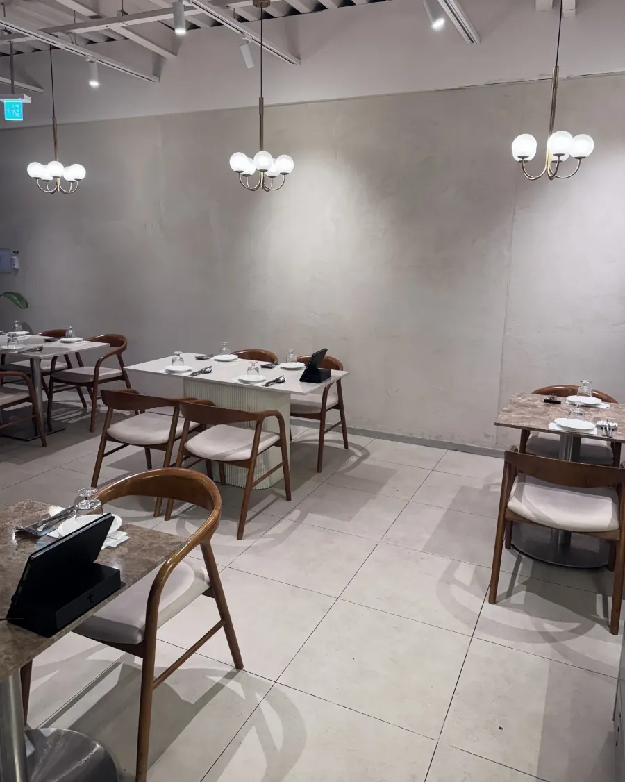 Interior of The Mignon Seoul in white tones with wood chairs