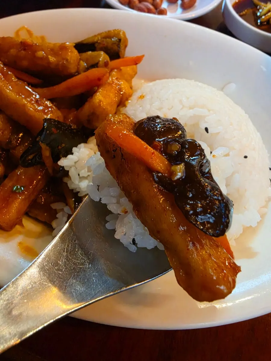 Scooping up eggplant and rice together