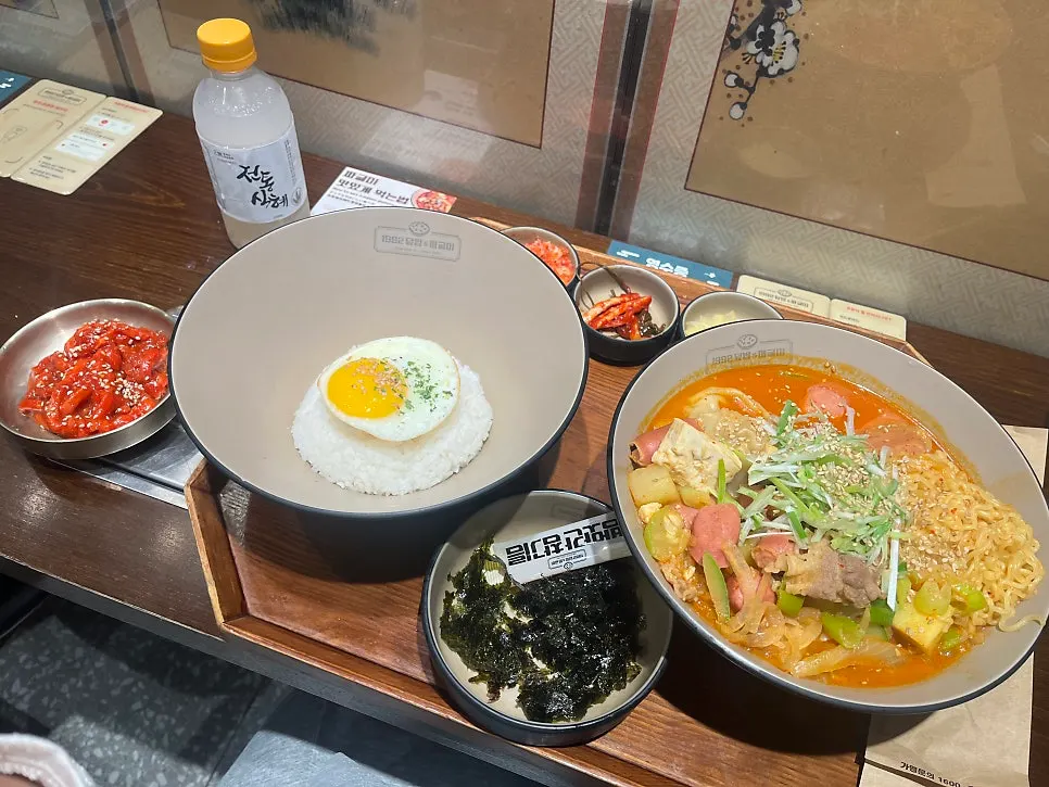 Table set with mixed doenjang jjageuli, rice, and side dishes
