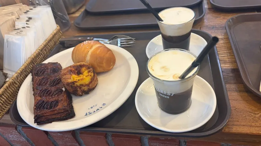 Nampan berisi salt bread, egg tart, dan latte