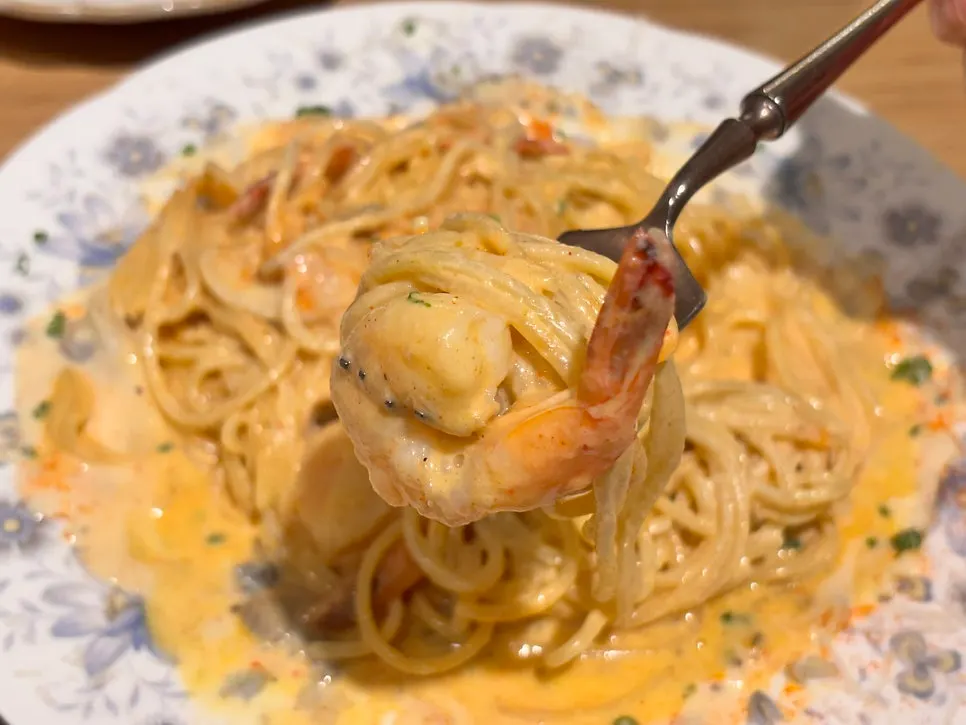 A forkful of shrimp and noodles from the spicy cream pasta